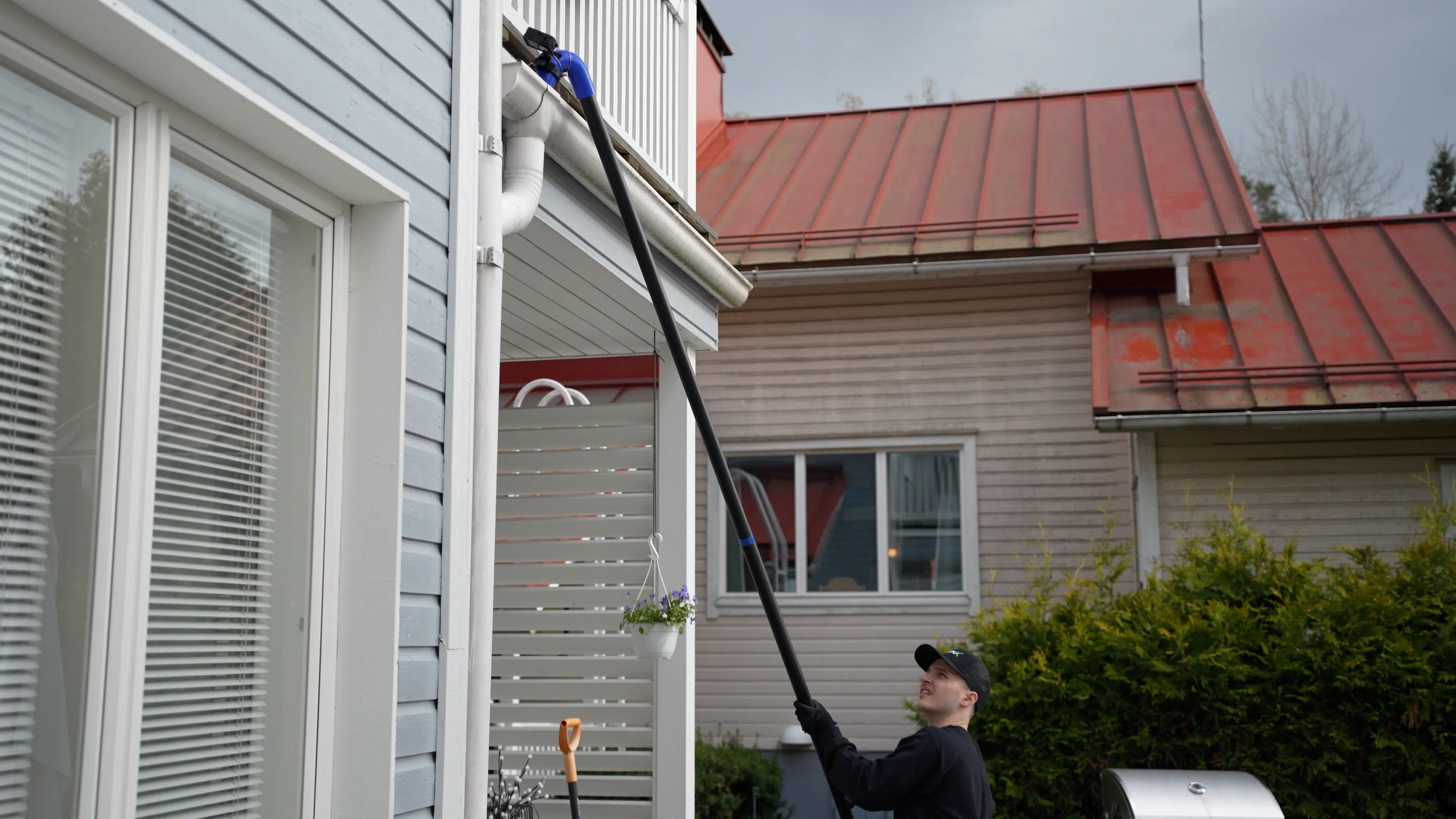 KouruX:n ammattilainen puhdistaa rännit ränni-imurilla maasta käsin